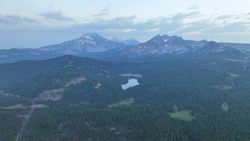 A summer sunrise illuminates the landscape around Three Sisters mountains, Oregon. These mountains and their surrounding forests, near Bend, provide exceptional hiking, biking, climbing, and camping.