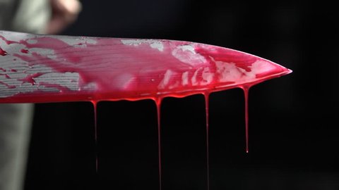 Close up of bloody knife with blood dripping