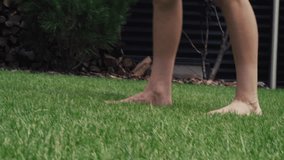Knee level shot of young football player passing soccer ball while training outside in the courtyard of the house on grass lawn. Athletic boy prepares for championship. Hobby and sports games concept. - Powered by Shutterstock - Get 15% off with code: PIKWIZARD15
