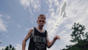 Athletic teenage boy wearing sportswear dribbling soccer ball preparing for competition. Young football player trains outside in courtyard of house. Hobby and sports games concept. Low angle shot. - Powered by Shutterstock - Get 15% off with code: PIKWIZARD15