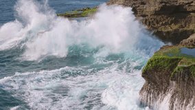 Rotating aerial shot of massive waves crashing against rugged cliffs on Lembongan Island, Bali. Captures the raw power of the ocean and dramatic coastal scenery. - Powered by Shutterstock - Get 15% off with code: PIKWIZARD15