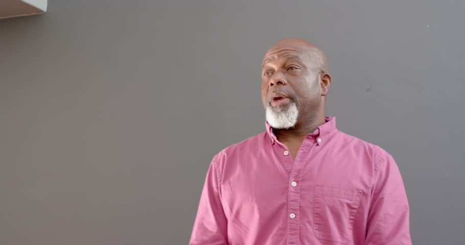 Close up of people talking to the camera, smiling man standing and looking to side indoors. the person is fully visible, standing, half body, talking to the camera with exaggerated hand movements.