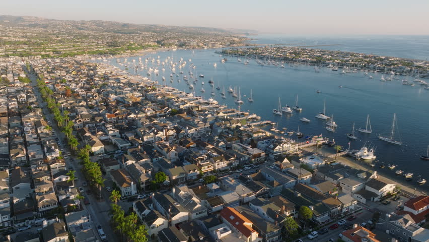 Explore the gorgeous vistas of Newport Beach, California from a mesmerizing 4K aerial perspective, capturing the beauty of the coastline, boats, cityscape, and luxurious waterfront living