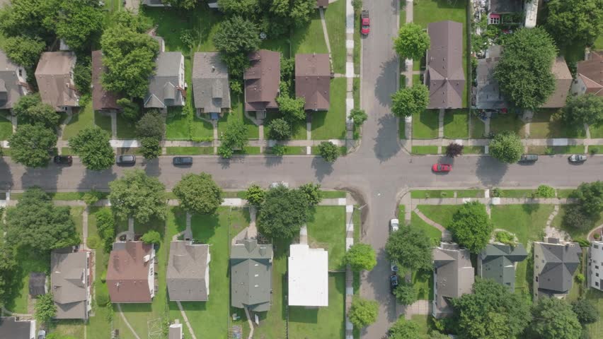 High angle view of red car passing through suburb area of Minnesota, USA during daytime.
