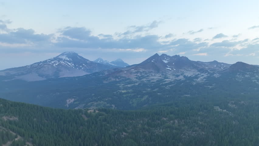 A summer sunrise illuminates the landscape around Three Sisters mountains, Oregon. These mountains and their surrounding forests, near Bend, provide exceptional hiking, biking, climbing, and camping.