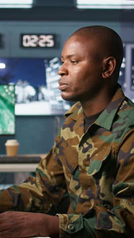 Vertical video Portrait of military agent working in control room, analyzing aerial reconnaissance data. Intelligence corps agent controlling drones attacking strategic targets, camera B