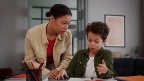 African American family talking little son boy child kid at home table studying learning distant education study learn difficult homework problem trouble talk argue with mother woman argument conflict - Powered by Shutterstock - Get 15% off with code: PIKWIZARD15