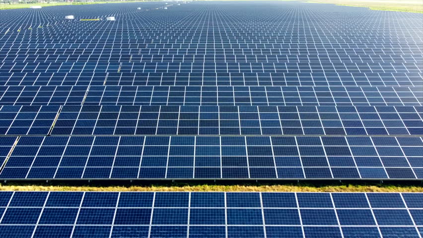 Aerial drone view flight over solar power station panels. Aerial top view of solar farm. Green energy, electrical innovation. Renewable Energy. Industrial Solar Energy Farm producing solar power.