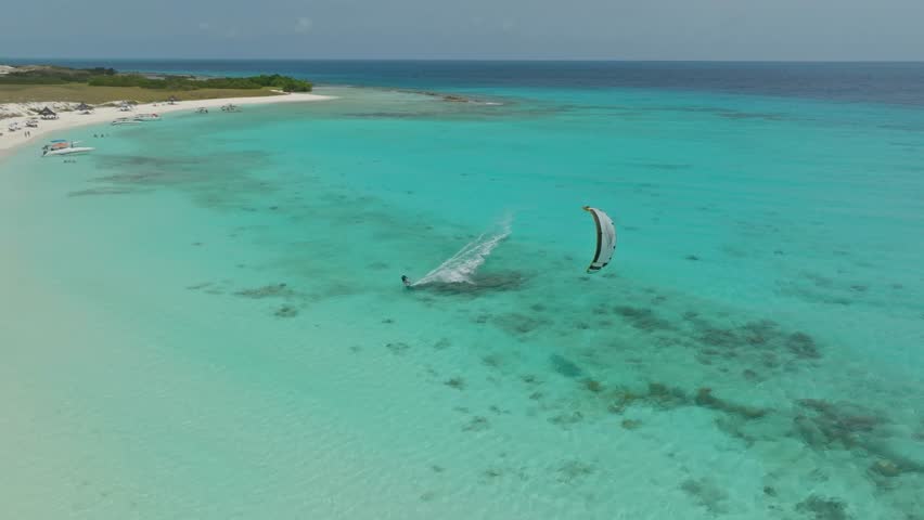 Kitesurfer jumping over the land bridge at Cayo Agua at Los Roques, Venezuela.