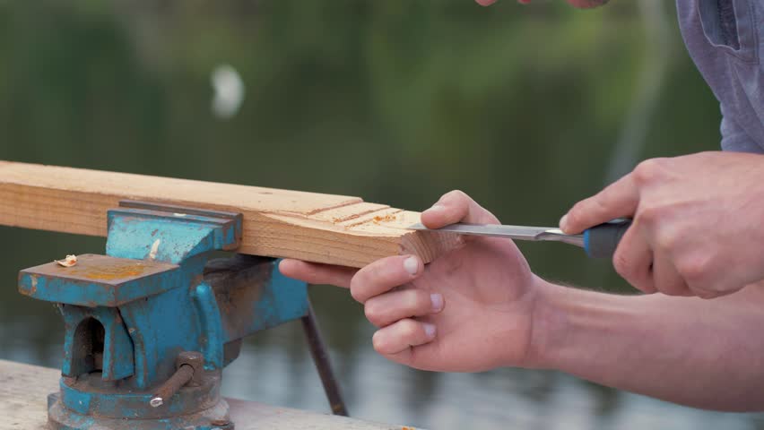Carpenter removes wood using a chisel