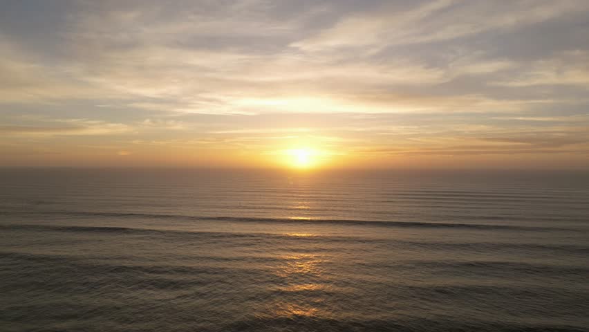 Aerial drone view of a perfect sunset over the Pacific Ocean during a golden and colorful sunset in Pacific Beach San Diego California with people enjoying the beautiful views by Crystal Pier