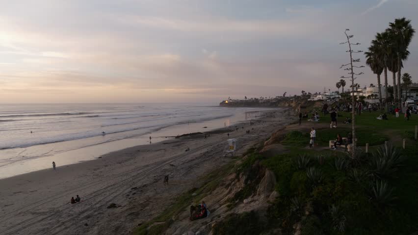 Aerial drone view of a perfect sunset over the Pacific Ocean during a golden and colorful sunset in Pacific Beach San Diego California with people enjoying the beautiful views by Crystal Pier