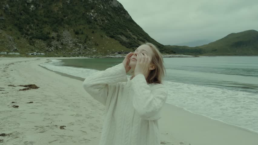 girl on beach in norway fixing hair
