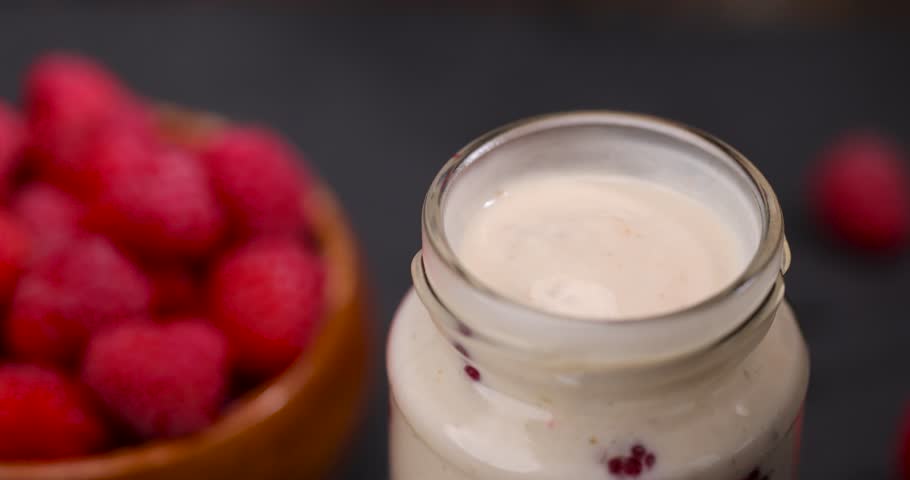 delicious and fresh yogurt with raspberry flavor and whole red raspberries, raspberry yogurt on the table