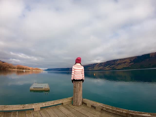 A lady sitting on the Glenorchy wharf, famous scenic spot along the  Lake Wakatipu