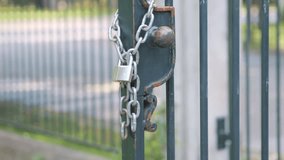 Old lock and chain on a metal gate, suggesting security in 4k slow motion 120fps - Powered by Shutterstock - Get 15% off with code: PIKWIZARD15