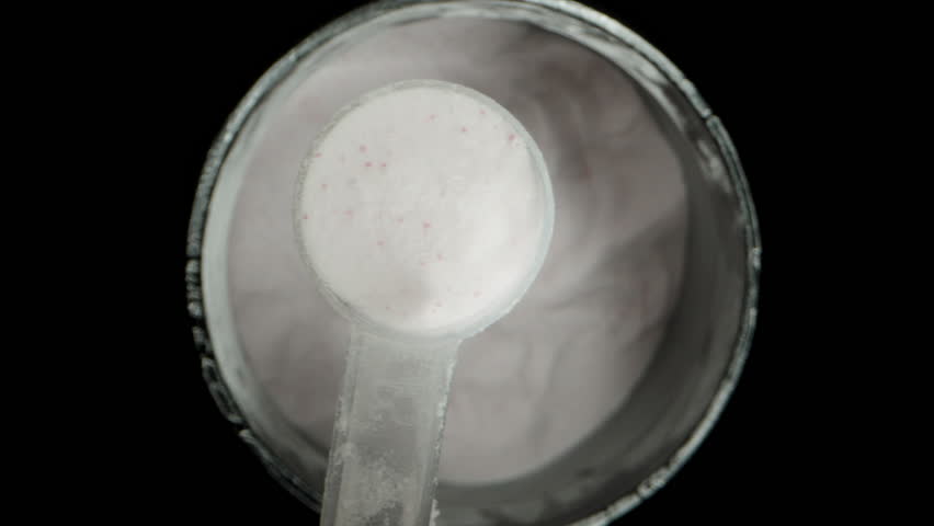 Camera Rises Up From A Container Of White Creatine Powder With A Full Measuring Spoon. Macro Dolly.