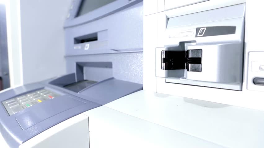 Closeup view hand inserting credit card into an ATM machine. cash machine withdrawing money in bank