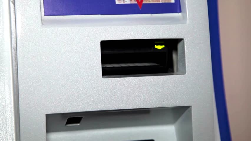 Hands of a woman inserting a cash at an ATM machine automatic teller machine