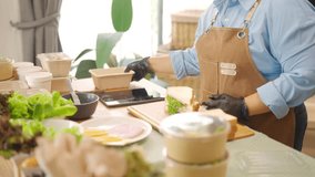 Portrait of Young Asian woman bakery shop owner preparing customer order sandwiches in delivery box on kitchen counter. Small business e-commerce online catering food and drink entrepreneur concept. - Powered by Shutterstock - Get 15% off with code: PIKWIZARD15