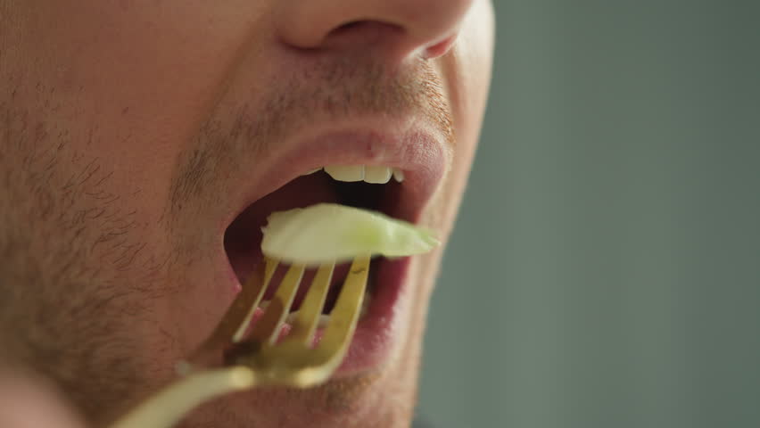 Close up mouth man eating salad vegetables vegan athlete healthy food guy male snack nutrition chew dieting lose weight balanced superfood delicious tasty vitamin health freshness lunch lettuce hungry