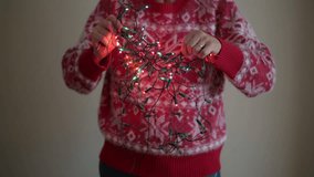 Person Wearing A Red Christmas Sweater Untangling The Christmas Tree Lights. - Powered by Shutterstock - Get 15% off with code: PIKWIZARD15