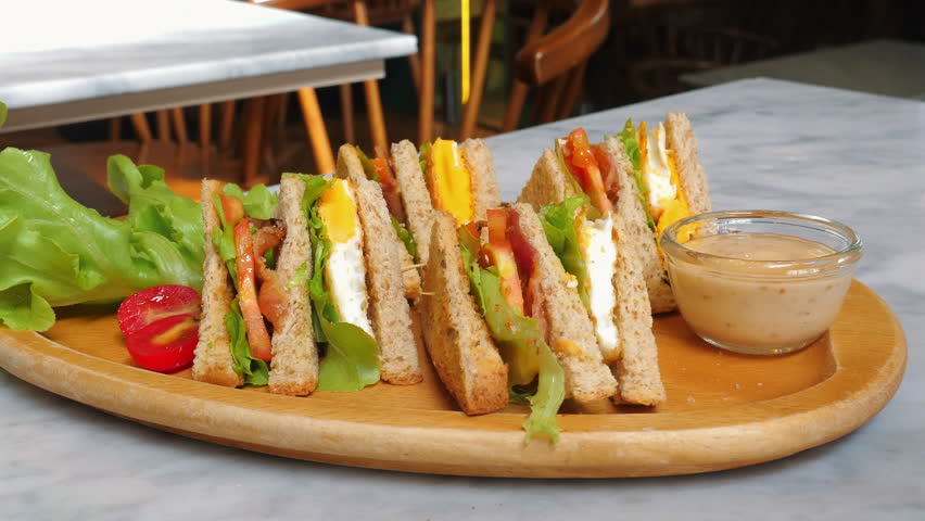Healthy club sandwiches served on wooden platter with dipping sauce and fresh vegetables, showcasing delicious and nutritious meal. Healthy Eating and Lifestyle.