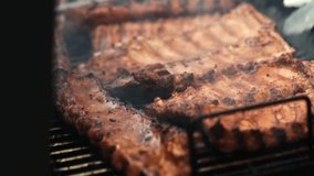 close up grilling pork ribs on barbecue grill outdoors summer. Preparing juicy pork meat on coal in smoke. BBQ. Picnic time with Grill outdoors party. 4k. - Powered by Shutterstock - Get 15% off with code: PIKWIZARD15