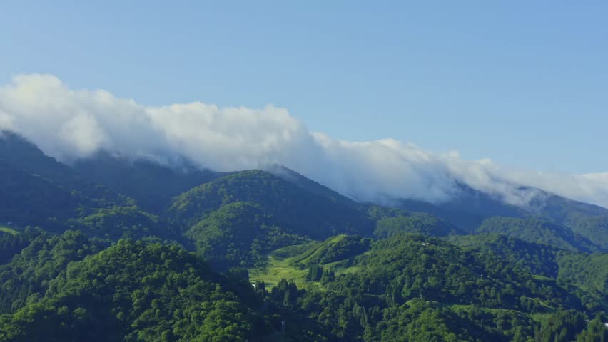 Drone footage: Big clouds moving over the mountains in summer