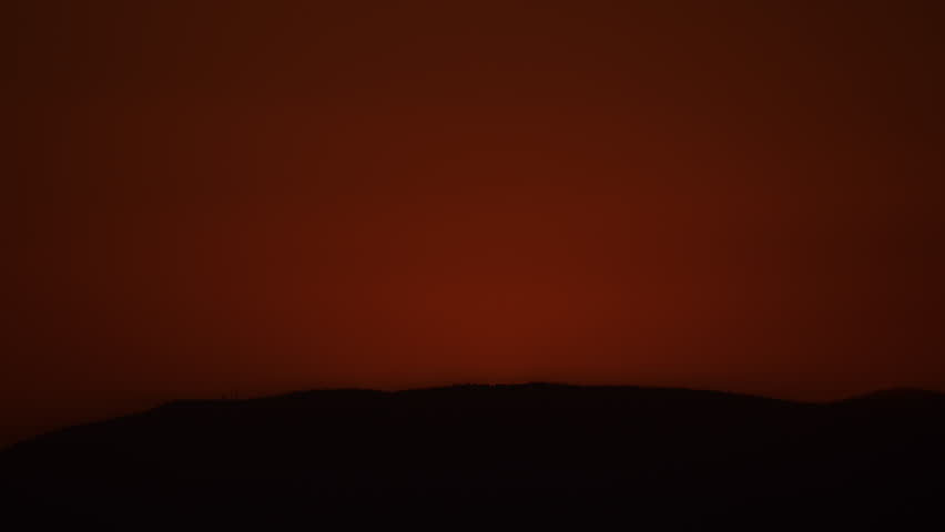 Zoom in to Extreme Closeup of Sun Rising Over a Hill into a Red Sky 4K Timelapse