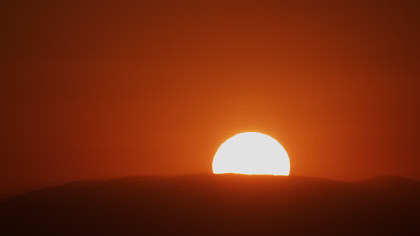 Zoom in to Extreme Closeup of Sun Rising Over a Hill into a Red Sky 4K Timelapse