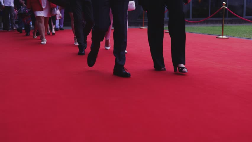 Red carpet with ropes and golden barriers on a luxury party entrance, cinema premiere film festival event award gala ceremony, wealthy rich guests arriving, outdoor decoration elements, summer day