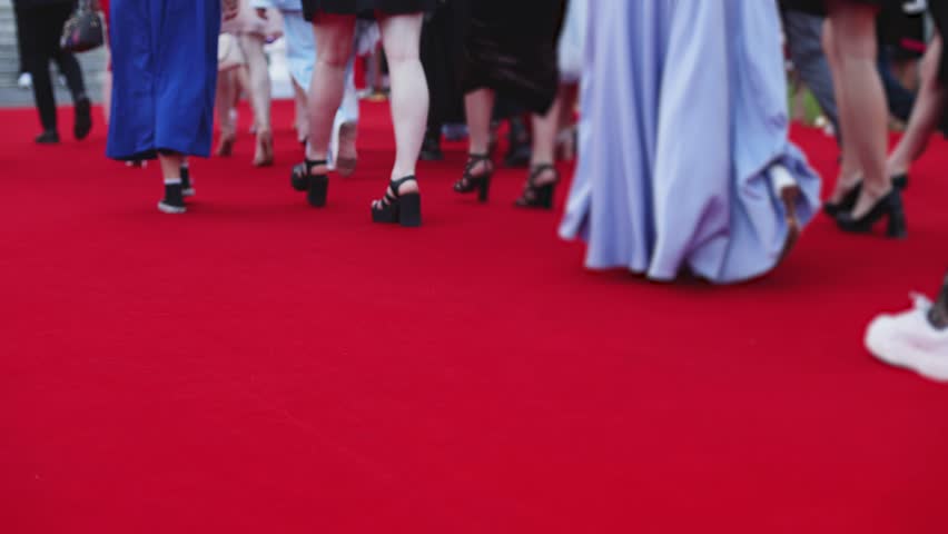 Red carpet with ropes and golden barriers on a luxury party entrance, cinema premiere film festival event award gala ceremony, wealthy rich guests arriving, outdoor decoration elements, summer day