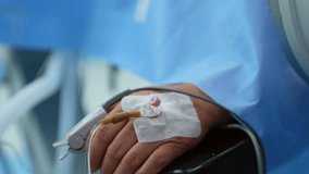 Iv drip is attached to the outer side of a palm and a sensor is on the thumb. Hand of the person undergoing surgery. Close up. - Powered by Shutterstock - Get 15% off with code: PIKWIZARD15