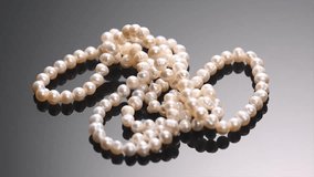 Pearl necklace rotating over black background, close up. Beautiful Natural pearls beads, elegant accessories. Slow motion - Powered by Shutterstock - Get 15% off with code: PIKWIZARD15