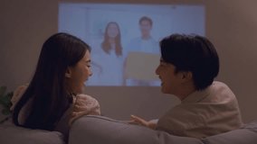 Asian young loving couple watch movie together in living room at home. Attractive new marriage man and woman having fun, sitting on sofa watch romantic video on TV during weekend activity in house. - Powered by Shutterstock - Get 15% off with code: PIKWIZARD15