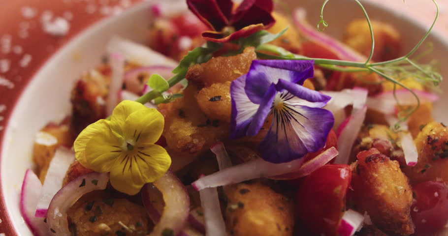 eautiful slow motion shot and close-up of a dish called “octopus casserole” with all its ingredients and decoration inside a restaurant kitchen.