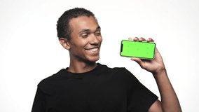 Smiling Man Holding Smartphone with Green Screen and Giving Thumbs Up - Powered by Shutterstock - Get 15% off with code: PIKWIZARD15