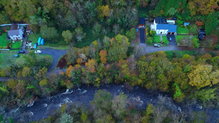 Traditional farmhouses built near the river cascading over the rocks Brecon Beacons