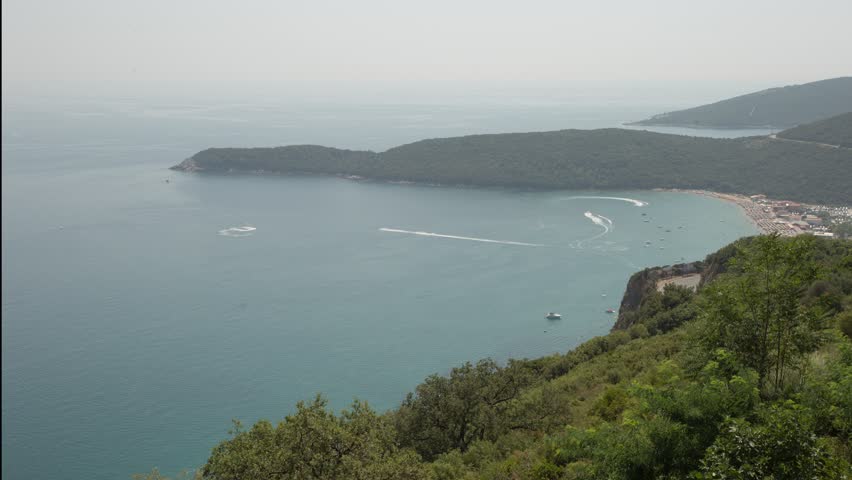 Timelapse Of Boats Sailing Around Jaz Beach On A Windy Day In Budva, Montenegro. aerial, wide shot