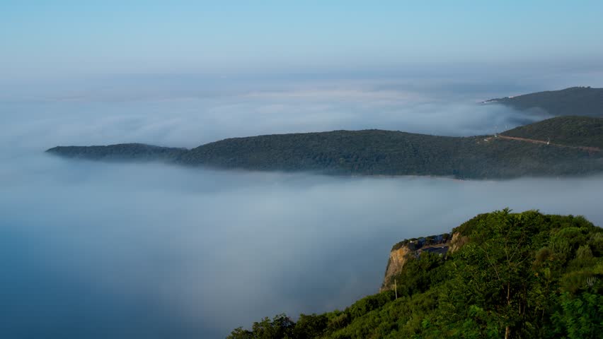 Timelapse Of Fog Fading Away Over The Jaz Beach During Daytime In Budva, Montenegro. aerial, wide shot