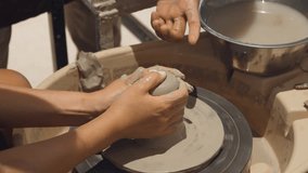 Woman's Hands Shaping Mound of Clay on Potter Wheel During Pottery Workshop. Teacher Assisting Student Helping to Sculpt Product - Detailed Close-up - Powered by Shutterstock - Get 15% off with code: PIKWIZARD15