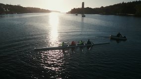 Aerial view Sports Rowing Boat in Ocean Bay at Dawn Canada, Halifax. The drone films a team of young rowers as they power their sports canoe through the calm waters of an ocean bay at dawn in Halifax. - Powered by Shutterstock - Get 15% off with code: PIKWIZARD15