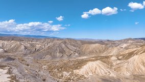 Panoramic aerial rises above the eroded hills of Tabernas Desert and curves across the distinctive film industry landscapes crossing dry creek beds, craggy hills, and dust blown valleys. - Powered by Shutterstock - Get 15% off with code: PIKWIZARD15