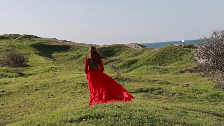  Beautiful red haired girl in metal medieval armor dress with sword standing in warlike pose