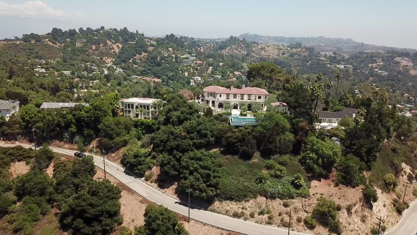 Panning Aerial View of Beverly Hills Mansions with Views of Sherman Oaks and the San Fernando Valley in Los Angeles, California During a Warm Summer Day