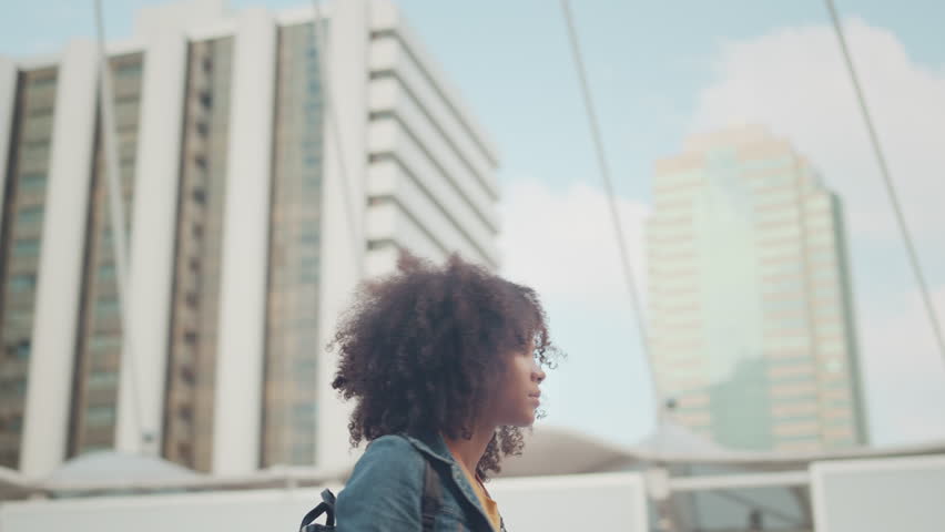 Happy young tourist Mixed race woman in good mood with camera standing outdoors in city, Smile young female tourist taking photo. Photographer taking pictures. Enjoying travel concept