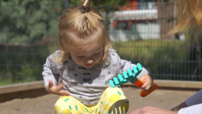 Young mother playing with her little son on the playground.