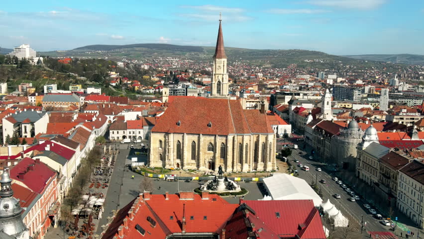 Aerial drone view of Saint Michael Church in Cluj, Romania. Cityscape, central square with people, old buildings