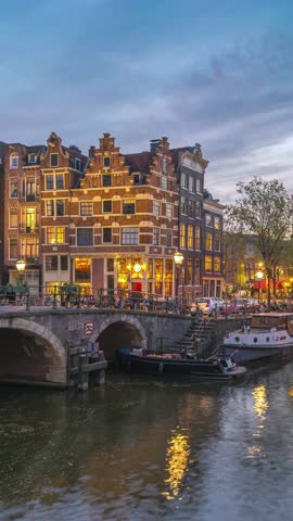 Amsterdam Netherlands time lapse day to night city skyline at canal waterfront (Vertical)